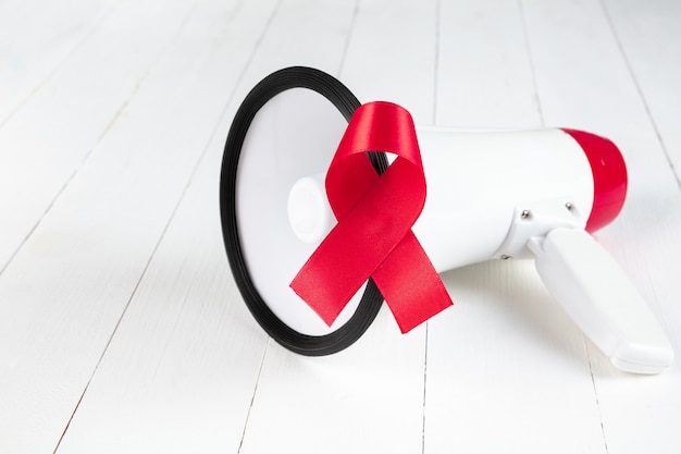 Nastro rosso del segno di consapevolezza dell'AIDS con il megafono