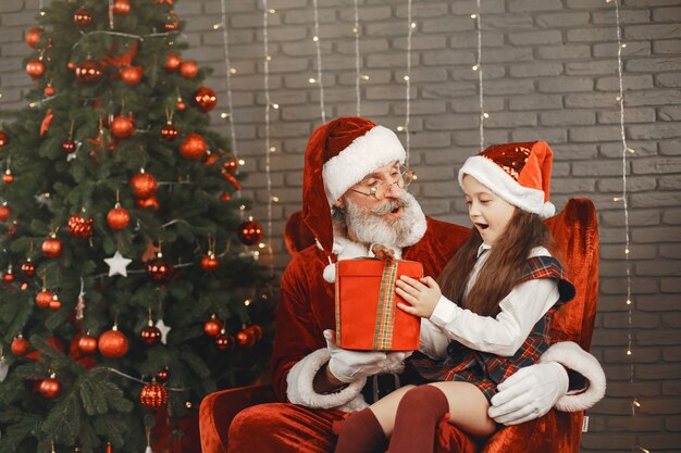 Natale, bambino e regali. Babbo Natale ha portato i regali al bambino. Bambina allegra che abbraccia Babbo Natale.