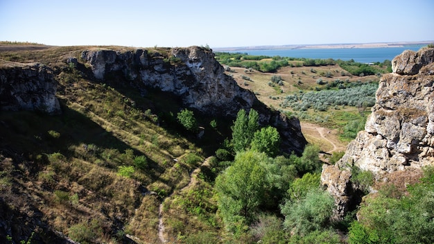 Natura della Moldavia, gola con pendii rocciosi, alberi rigogliosi e sentiero escursionistico sul fondo