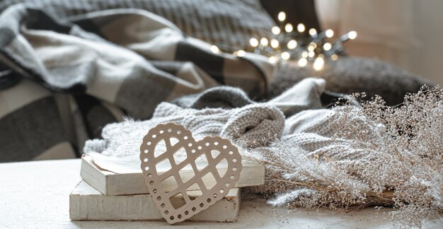 Natura morta con cuori decorativi e libri su uno sfondo sfocato con bokeh. Il concetto di San Valentino e comfort domestico.