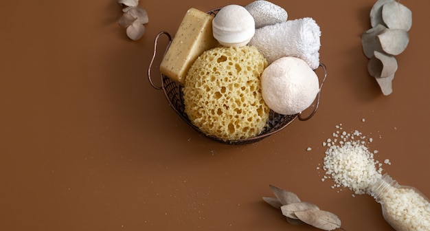 Natura morta con spugna da bagno, bombe da bagno, sapone e vista dall'alto di sale marino bianco.