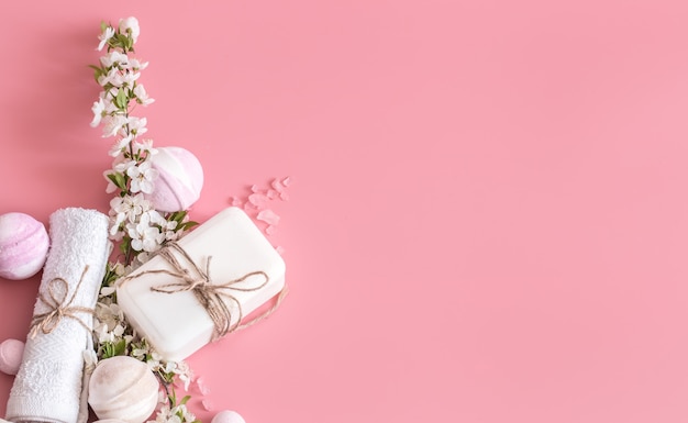 Natura morta della stazione termale su fondo rosa con i fiori della molla