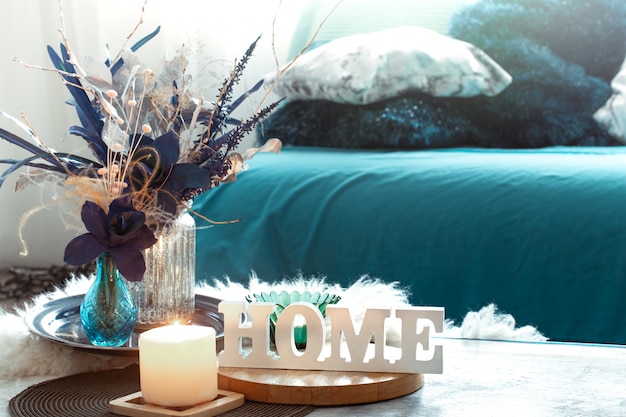 Natura morta nei toni del blu, con scritta home in legno ed elementi decorativi nel soggiorno.