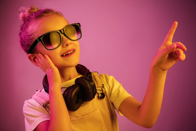 Neon ritratto di giovane ragazza con le cuffie che gode della musica.