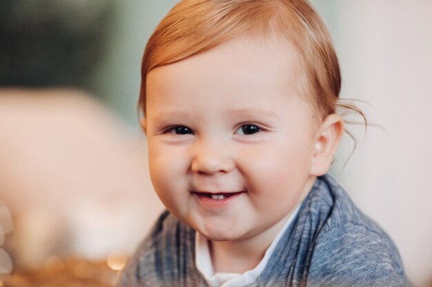 Neonato adorabile che sorride alla macchina fotografica. sfondo sfocato.