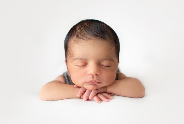 Neonato che posa pacificamente piccolo neonato grazioso e simpatico