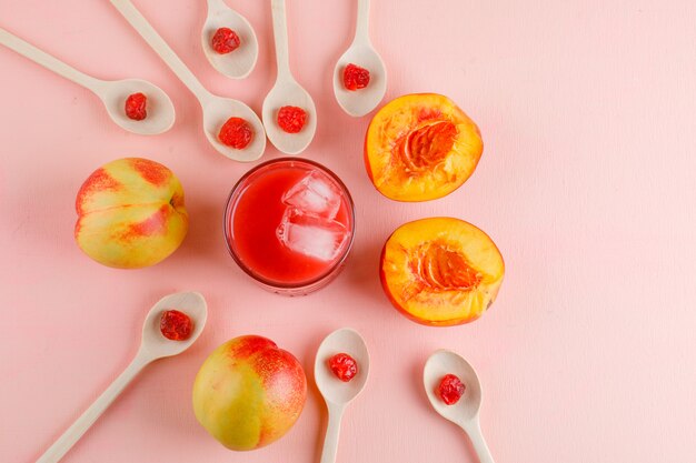 Nettarine con ciliegia secca, succo sulla superficie rosa, vista dall'alto.