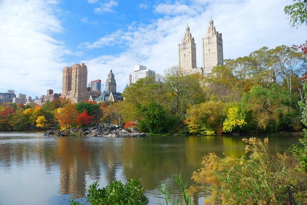 New York City Central Park in autunno con i grattacieli di Manhattan e gli alberi colorati sul lago con la riflessione.