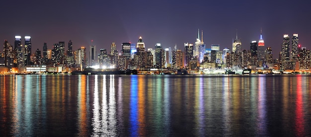 New York City Manhattan Midtown skyline di notte con luci riflesse sul fiume Hudson visto dal New Jersey Weehawken waterfront.