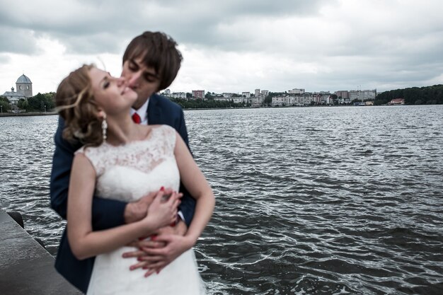 Newlyweds che baciano con bellissimo sfondo del paesaggio