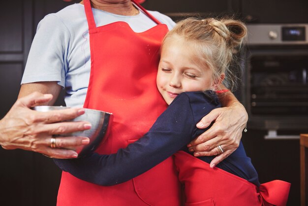 Nipote che abbraccia la nonna in cucina