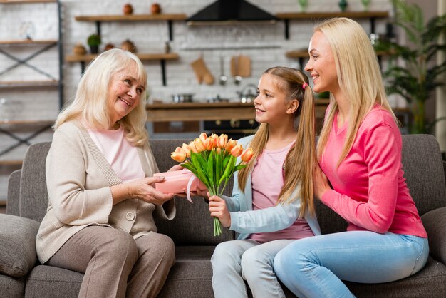 Nipote che offre il mazzo di fiori a sua nonna