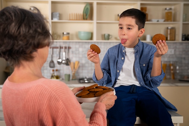 Nipote e nonna del tiro medio con i biscotti