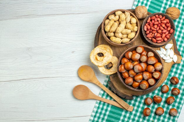 Nocciole crude fresche di vista superiore con le arachidi sulla noce di film dello spuntino dell'alimento della pianta del dado della tavola bianca