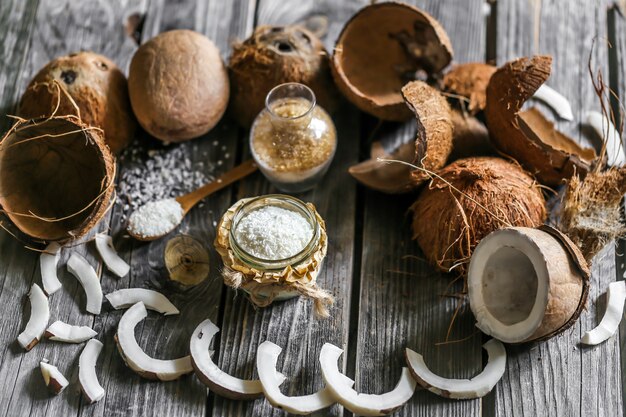 Noci di cocco fresche rotte sulla parete in legno