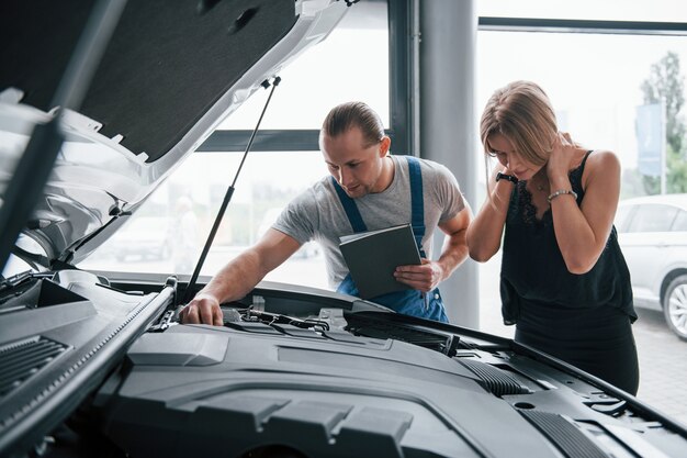 Non ci vorrà molto. Risultati della riparazione. Uomo fiducioso che mostra che tipo di danno è stata presa la sua auto