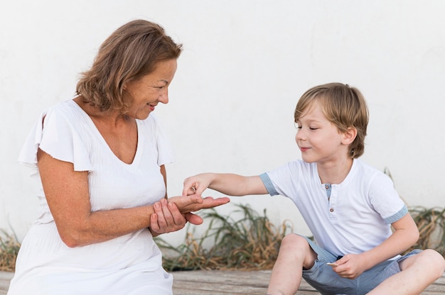 Nonna e bambino con conchiglie a tiro medio