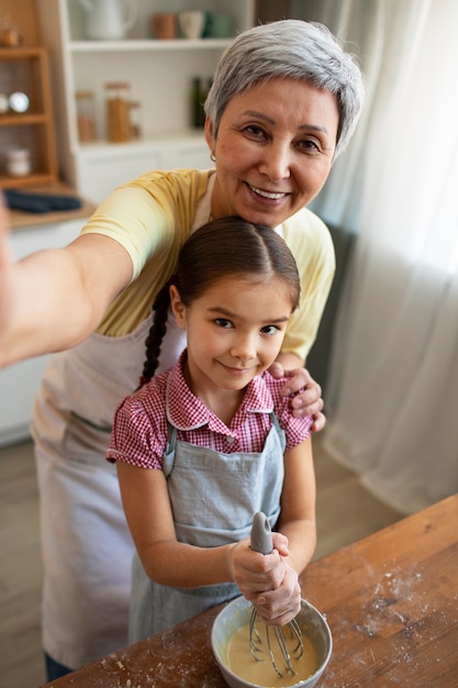 Nonna e ragazza del colpo medio che cucinano insieme