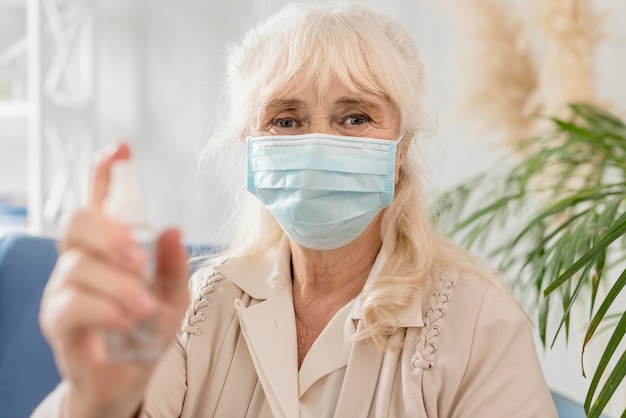 Nonna ritratto con maschera e disinfettante