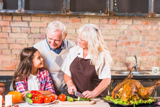 Nonni che cucinano tacchino con la nipote