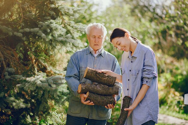 Nonno con nipote in un cantiere con legna da ardere in mano