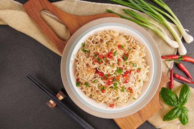 Noodles istantanei e zuppa per mangiare cipolle e peperoni affettati e mettere il maiale. Vista dall'alto