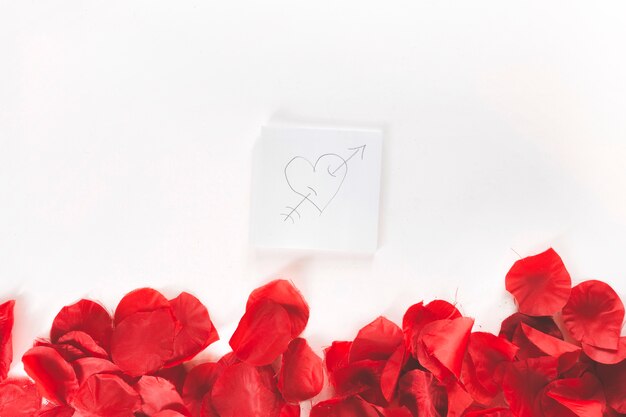 Nota appiccicosa con cuore sopra petali