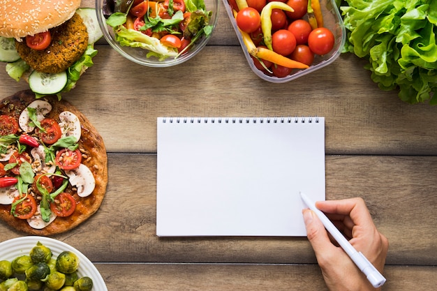 Notebook mock-up accanto a deliziosi piatti vegani