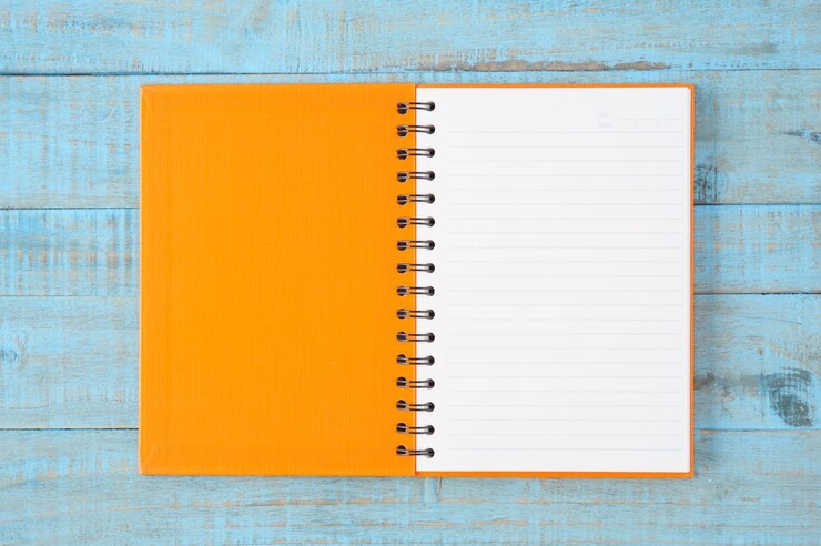 Foto gratuito notebook sulla tavola di legno blu