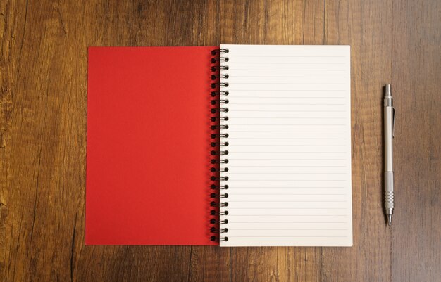 notepad rosso con una penna vicino
