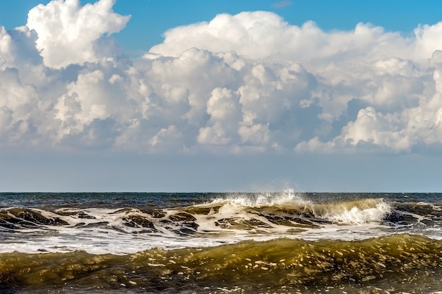 Nubi di tempesta in arrivo e onde che si infrangono sulla spiaggia di Kijkduin a L'Aia