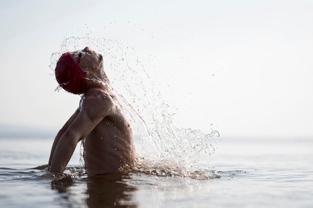 Nuotatore a metà colpo che spruzza fuori dall'acqua