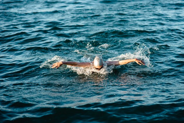 Nuotatore con cuffia e occhiali che nuotano in acqua