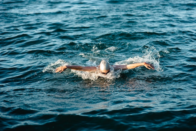 Nuotatore con cuffia e occhiali che nuotano in acqua