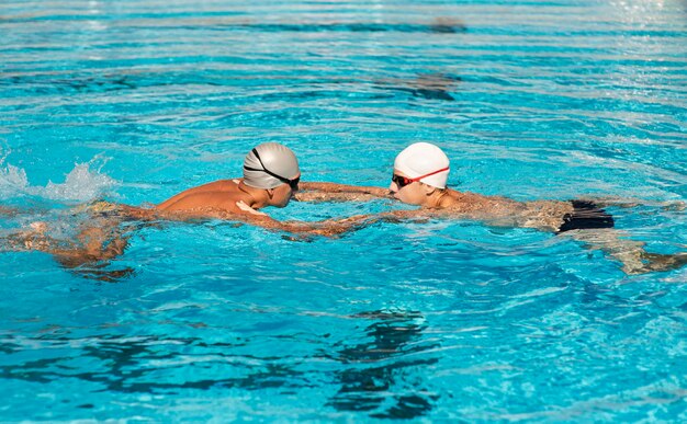 Nuotatori maschi che nuotano nella piscina