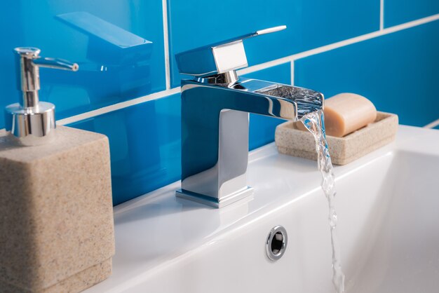 Nuovo e moderno rubinetto in acciaio con lavabo in ceramica in bagno