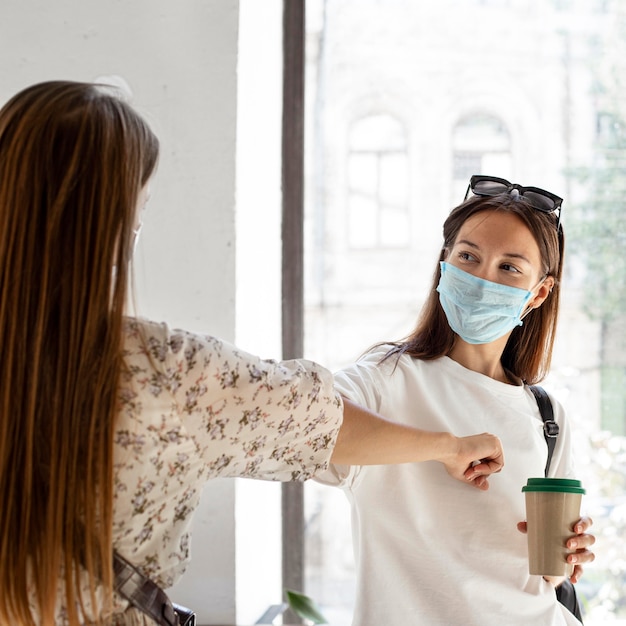 Nuovo normale con maschera facciale e protuberanza al gomito