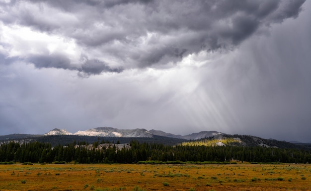 Nuvole e un bellissimo campo con lo sfondo delle montagne