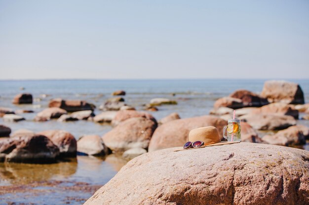 Occhiali da sole, cappello e bevande rinfrescanti sulla spiaggia