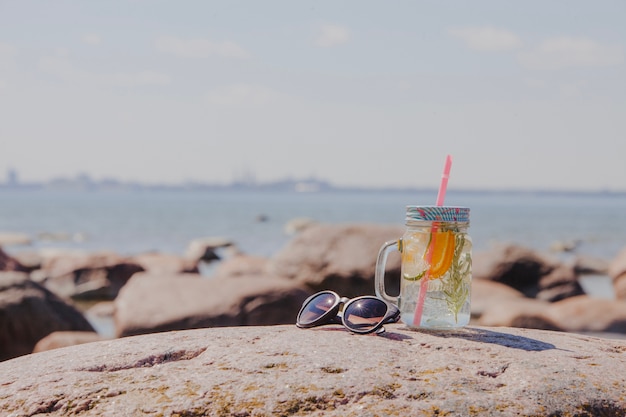 Occhiali da sole con bibita rinfrescante sulla spiaggia