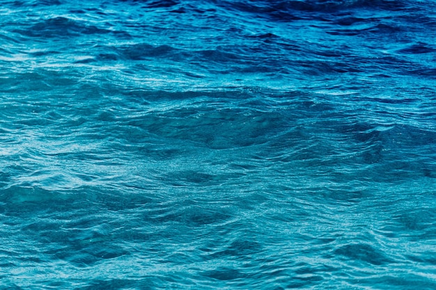 Oceano blu brillante con sfondo di onde lisce