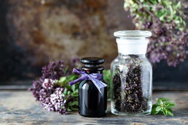 Olio essenziale di origano in bottiglia di vetro su fondo di legno. copia spazio