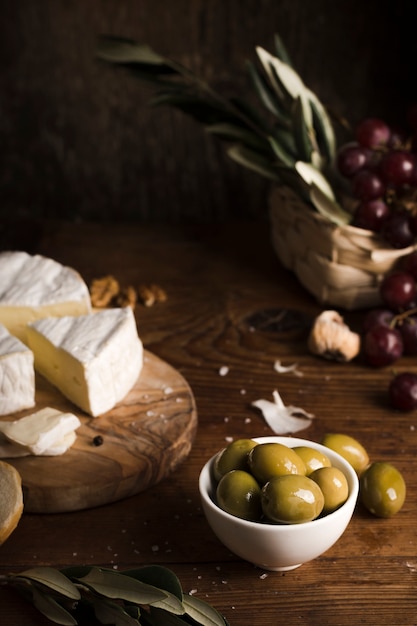 Olive dell'angolo alto e composizione nel formaggio sulla tavola