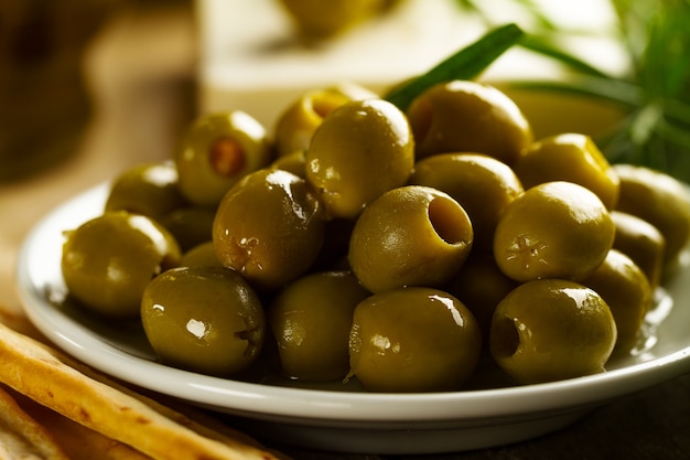Olive greche gustose fresche con grissini e rosmarino fresco <. Avvicinamento. Il cibo mediterraneo.