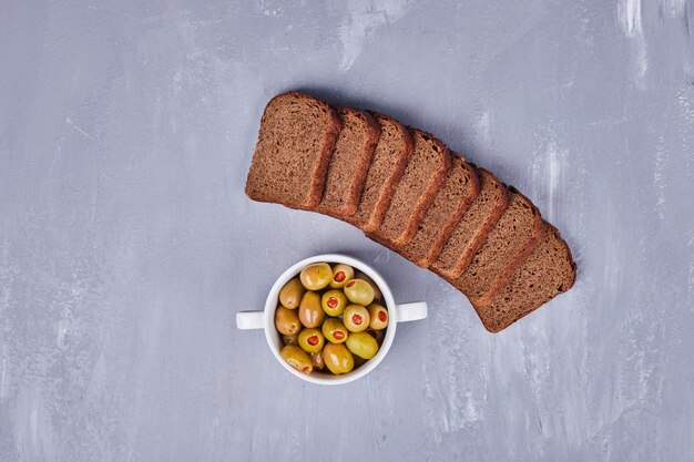 Olive marinate con fette di pane nero.