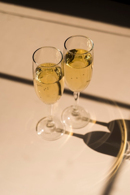 Ombra di flute di champagne riempito su sfondo bianco