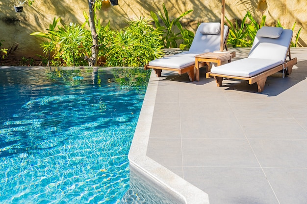 Ombrellone e sedia intorno alla piscina all'aperto in hotel resort per il tempo libero delle vacanze