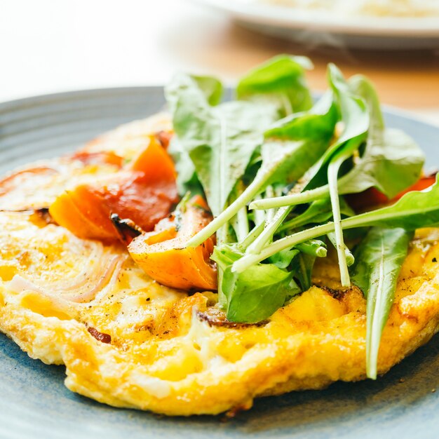 Omelette delle uova fritte in piatto bianco