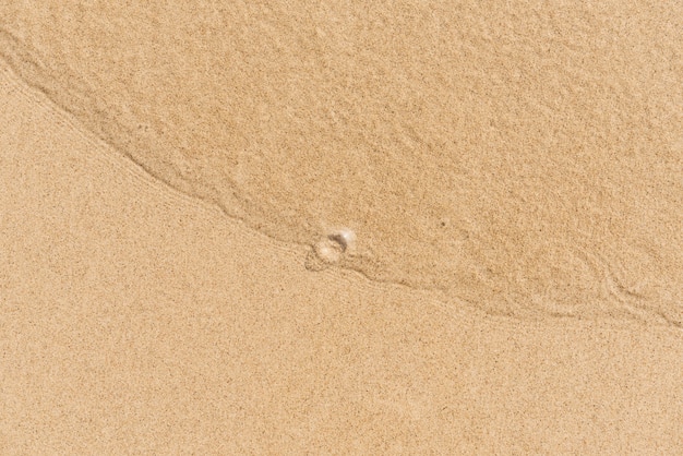 Onda morbida dell&#39;oceano blu sulla spiaggia di sabbia. Sfondo. Messa a fuoco selettiva.