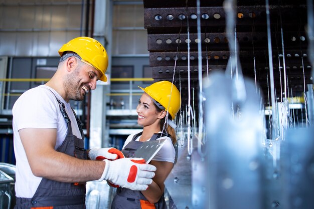 Operai che lavorano insieme nella linea di produzione industriale del metallo hall